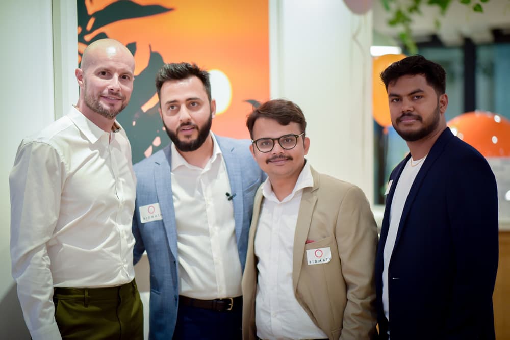 Four Bidmath team members posing together at an event